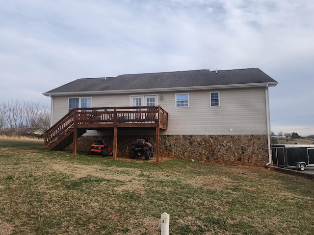 back of property with a yard, a wooden deck, and stairs