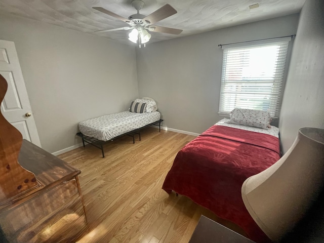 bedroom featuring light wood-style flooring, baseboards, and ceiling fan