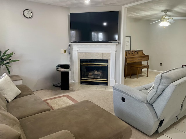 living area featuring light colored carpet, a fireplace, baseboards, and a ceiling fan