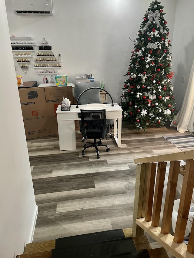 home office with a wall mounted air conditioner and wood finished floors