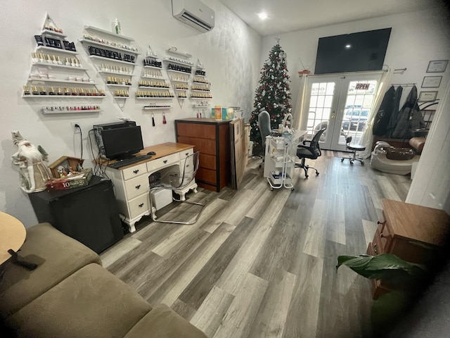 home office with light wood-type flooring, french doors, and a wall unit AC