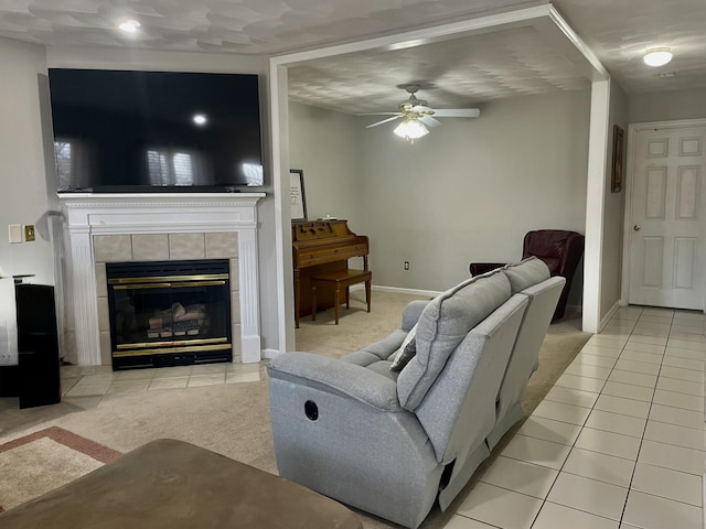 living area with baseboards, light tile patterned flooring, ceiling fan, and a fireplace