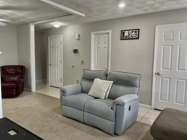 living area with light carpet, light tile patterned flooring, baseboards, and ceiling fan