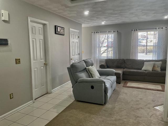 living area with light tile patterned flooring, baseboards, a wealth of natural light, and light carpet