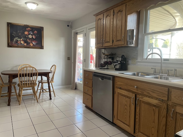 kitchen with a sink, dishwasher, a wealth of natural light, and light countertops