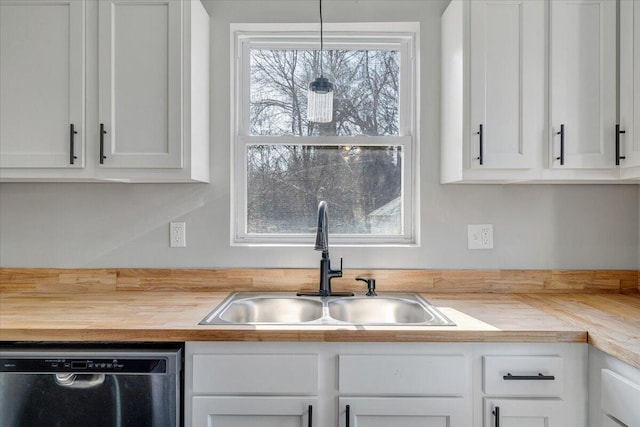 kitchen with stainless steel dishwasher, a sink, white cabinetry, and butcher block countertops