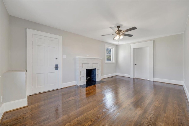 unfurnished living room with dark wood finished floors, a fireplace, baseboards, and ceiling fan