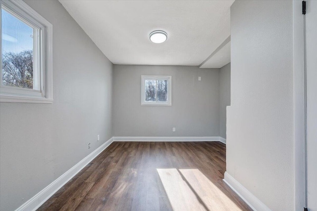 unfurnished room with dark wood-style floors and baseboards