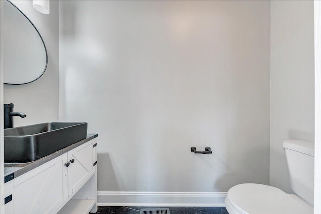 bathroom featuring vanity, toilet, and baseboards
