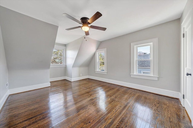 additional living space with baseboards, wood finished floors, a ceiling fan, and vaulted ceiling