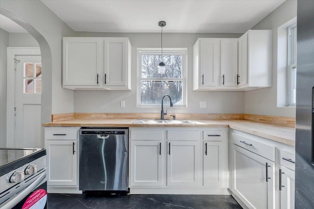 kitchen featuring white cabinets, arched walkways, appliances with stainless steel finishes, and a sink