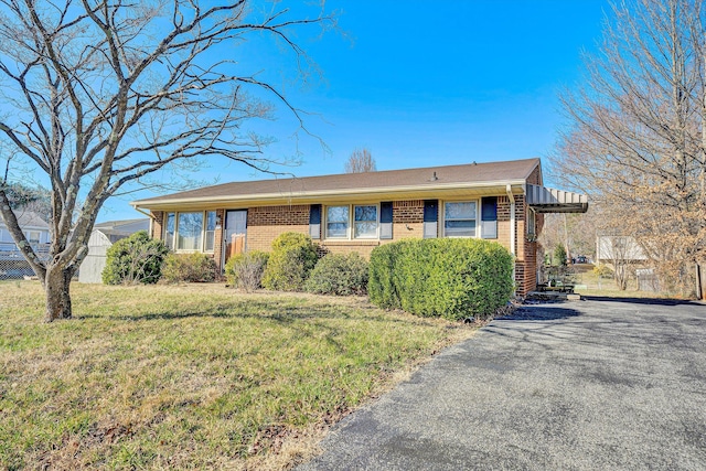 ranch-style home with brick siding and a front yard