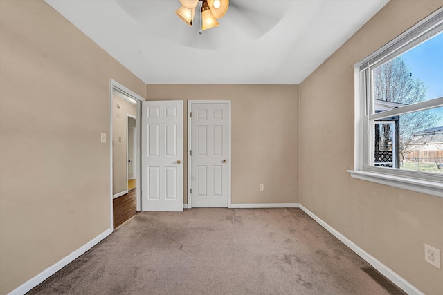 unfurnished bedroom with visible vents, baseboards, carpet, and ceiling fan