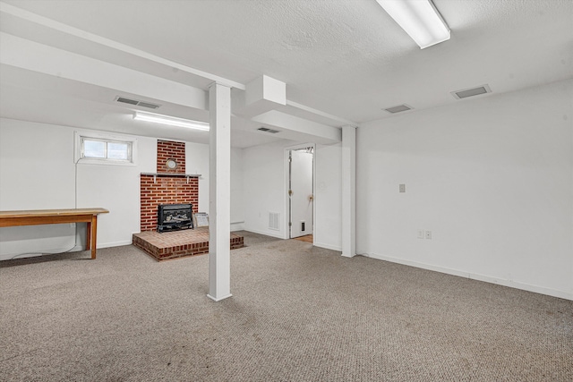 basement featuring visible vents, a textured ceiling, and carpet