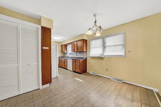 kitchen featuring white appliances, light floors, visible vents, and brown cabinets