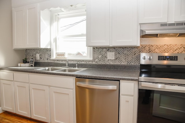 kitchen featuring under cabinet range hood, white cabinets, appliances with stainless steel finishes, and dark countertops