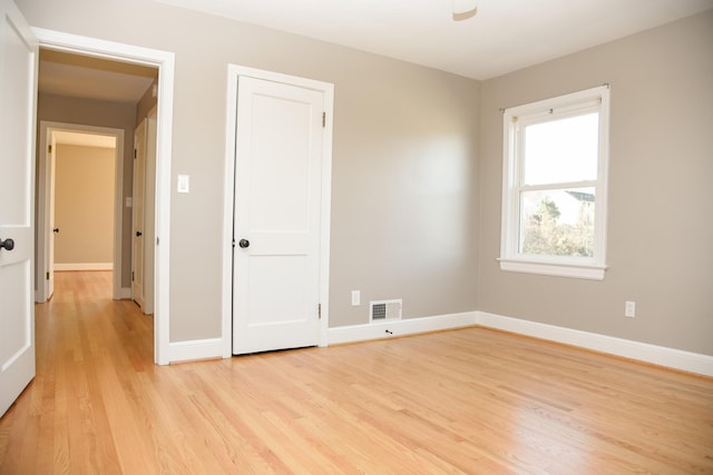 unfurnished bedroom with baseboards, visible vents, and light wood-type flooring