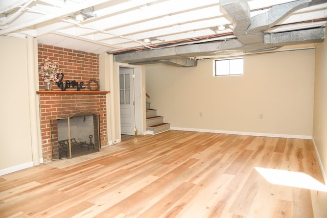 basement with a brick fireplace, stairway, wood finished floors, and baseboards