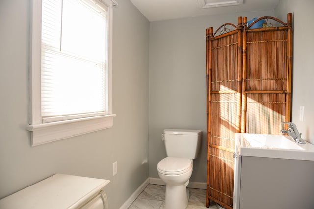 half bath with marble finish floor, toilet, vanity, and baseboards