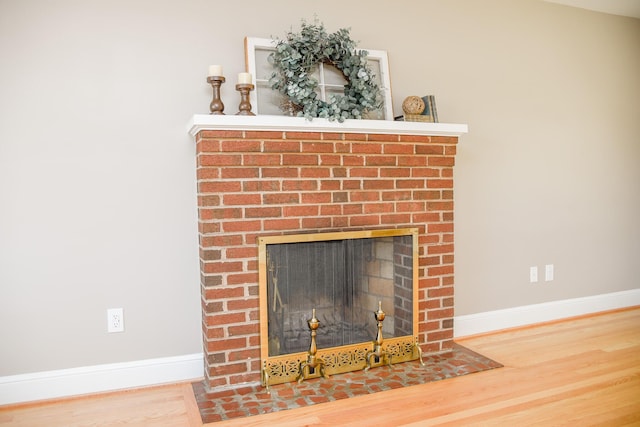 room details with a brick fireplace, wood finished floors, and baseboards