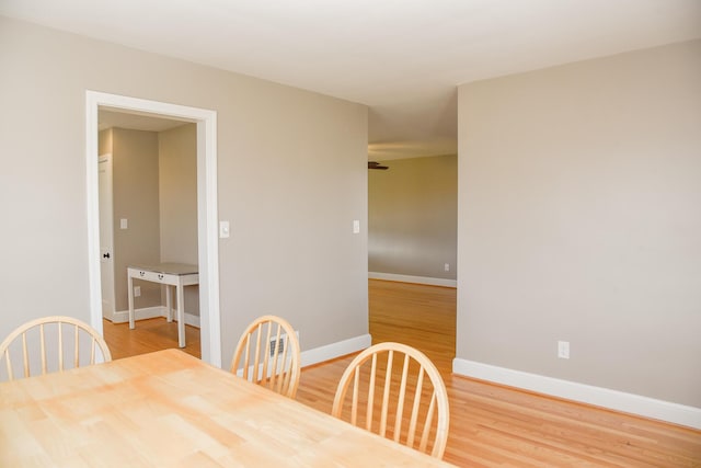 dining area with baseboards and wood finished floors