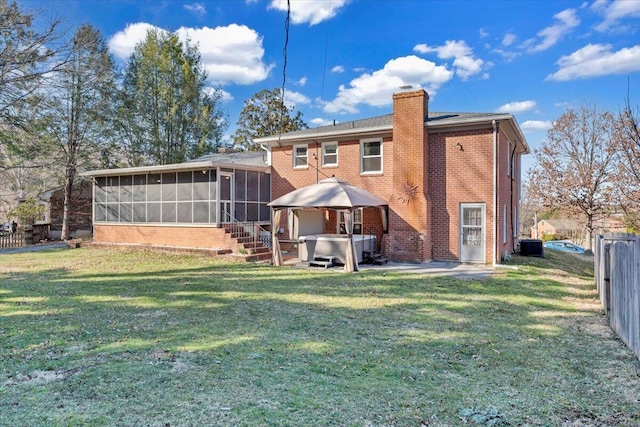 back of property featuring a patio, fence, a sunroom, a hot tub, and brick siding