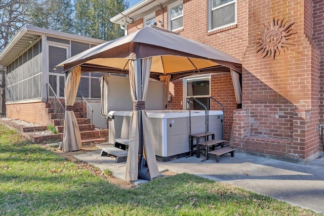 exterior space with brick siding and a hot tub