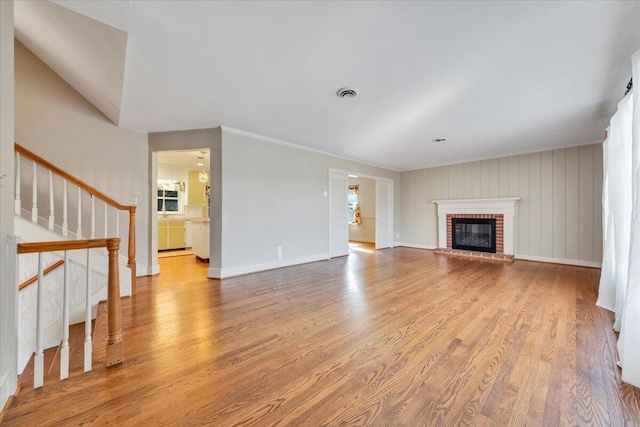 unfurnished living room featuring visible vents, baseboards, and wood finished floors