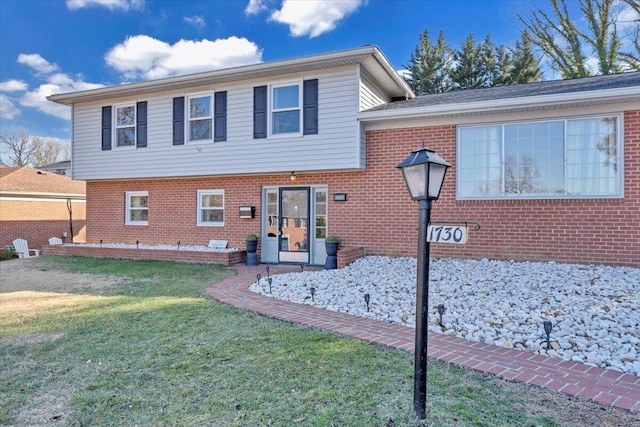 view of front of home with brick siding and a front lawn