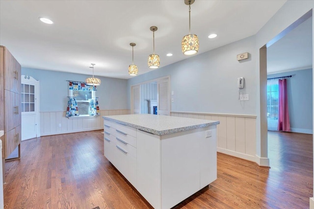 kitchen featuring wainscoting, light countertops, and wood finished floors