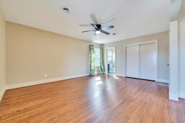 unfurnished bedroom with visible vents, baseboards, a closet, and wood finished floors