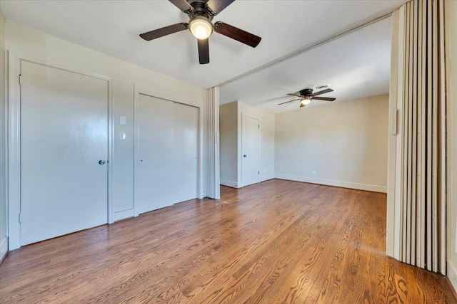 unfurnished bedroom with wood finished floors, baseboards, and ceiling fan