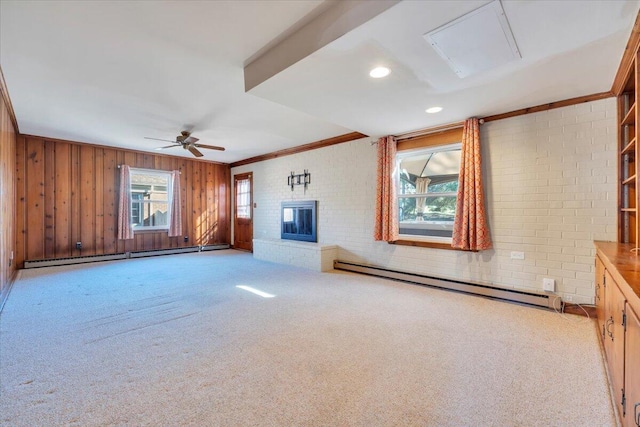 unfurnished living room with a ceiling fan, brick wall, a baseboard radiator, a baseboard heating unit, and carpet flooring