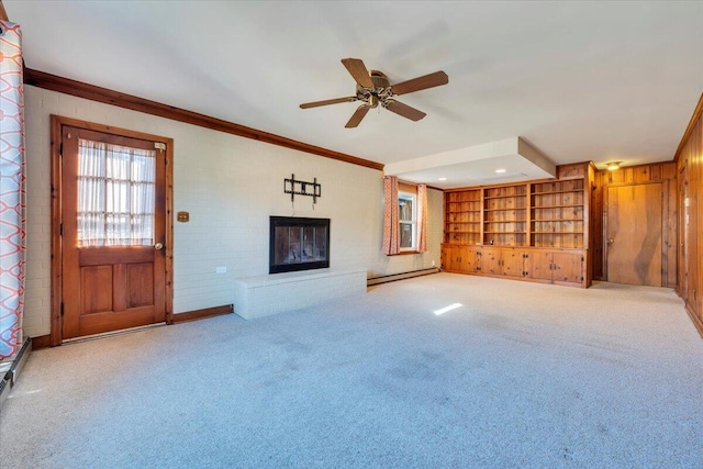 unfurnished living room with a glass covered fireplace, carpet flooring, baseboard heating, and ornamental molding