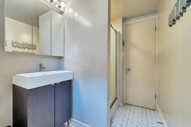 bathroom with tile patterned floors, an enclosed shower, vanity, and baseboards