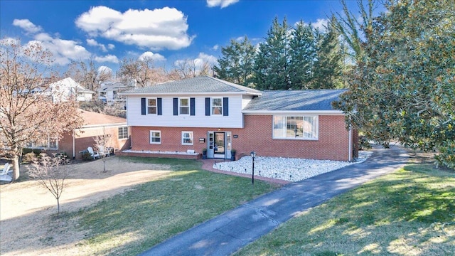 split level home with a front lawn and brick siding