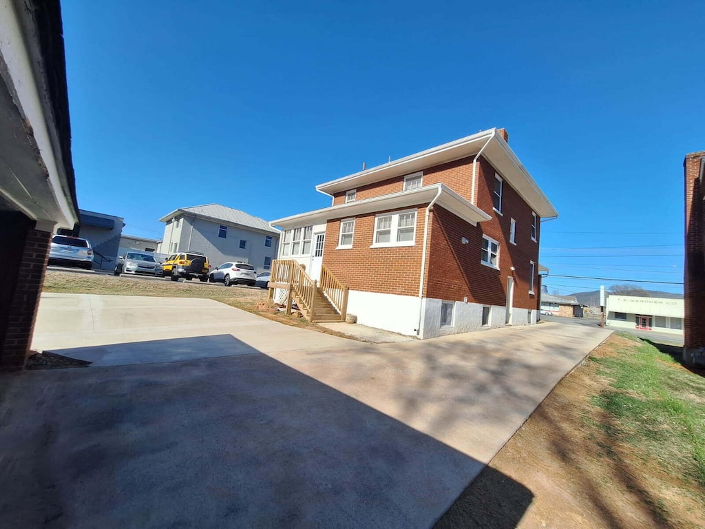 view of home's exterior featuring a residential view, brick siding, and driveway