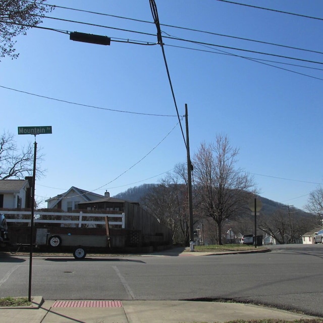 view of street with a mountain view, curbs, and sidewalks