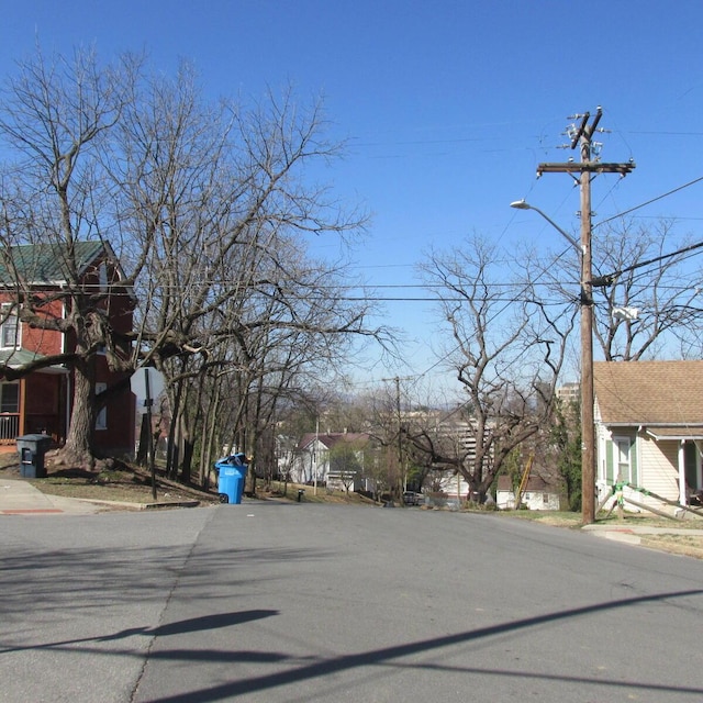 view of road with traffic signs, street lights, and sidewalks