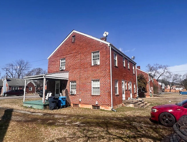 exterior space with cooling unit and brick siding