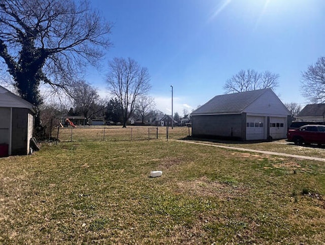 view of yard featuring an outdoor structure, fence, and a detached garage