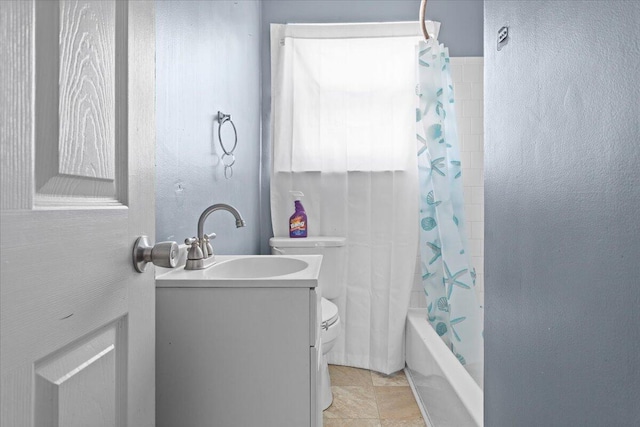 full bathroom with shower / bath combo with shower curtain, toilet, vanity, and a textured wall