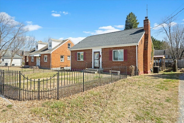 view of front facade featuring brick siding, a front lawn, a fenced front yard, cooling unit, and a chimney