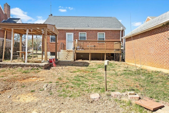 rear view of house featuring brick siding and a deck