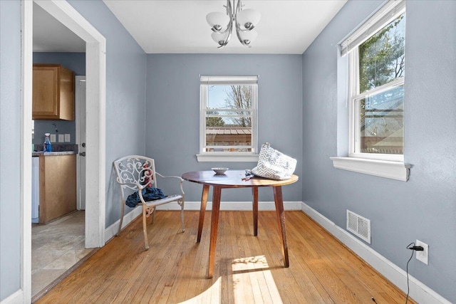 sitting room with light wood-type flooring, visible vents, plenty of natural light, and baseboards