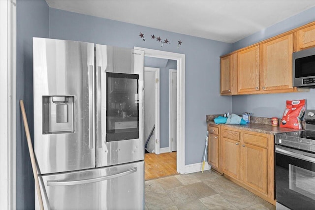 kitchen featuring baseboards and stainless steel appliances