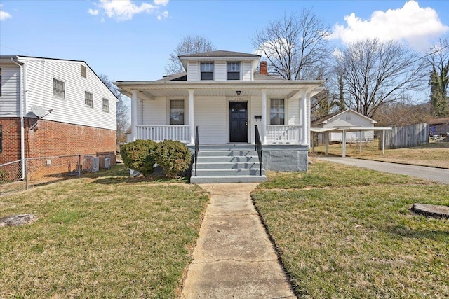 bungalow featuring covered porch, a front yard, and fence