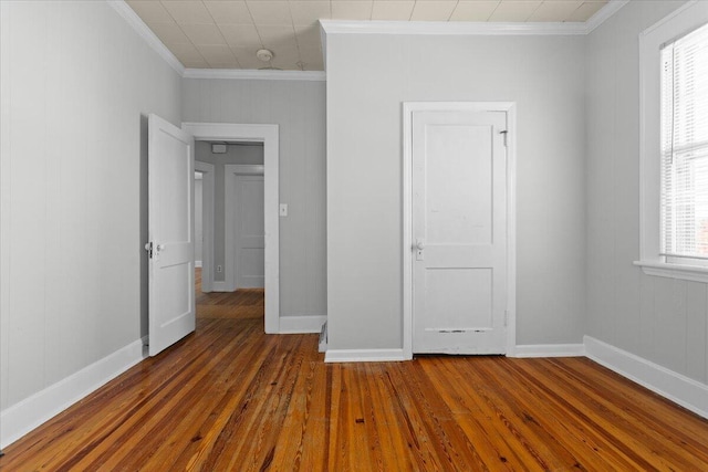 unfurnished bedroom with ornamental molding, baseboards, and hardwood / wood-style floors