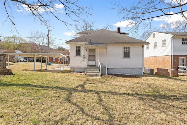 back of property featuring fence, entry steps, central AC unit, a lawn, and a chimney