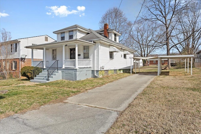 view of front of house with a carport, covered porch, a chimney, and a front lawn